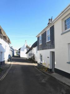 an empty street in a town with white buildings at Littlecot in Malborough