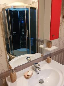 La salle de bains est pourvue d'un lavabo et d'un grand miroir. dans l'établissement Apartament me qera Lungomare Vlore Mari, à Vlorë