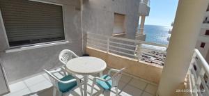 einen Balkon mit einem Tisch, Stühlen und Meerblick in der Unterkunft Apartamento Aquarium Park, 1ª linea de playa, para 4 personas in Calpe