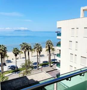 - une vue sur la plage depuis le balcon d'un bâtiment dans l'établissement Apartament me qera Lungomare Vlore Mari, à Vlorë