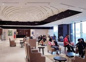a lobby with people sitting in chairs in a building at Hilltop Service Apartment at Genting Highland in Genting Highlands