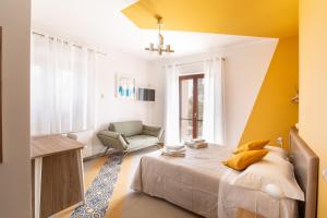 1 dormitorio con 1 cama y 1 silla en Locanda Ballarò Relais di Campagna, en Deliceto