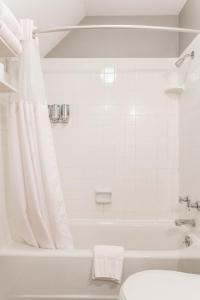 a white bathroom with a tub and a toilet at William Gillis at Southmoreland on the Plaza in Kansas City