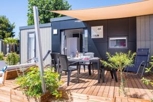 een tiny house met een tafel en stoelen op een terras bij Camping Vendres in Vendres