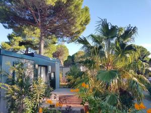 een huis met veel planten en bomen bij Camping Vendres in Vendres