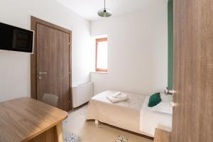 a small bedroom with a bed and a table at Locanda Ballarò Relais di Campagna in Deliceto