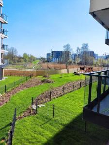 a view of a field of grass with a fence at Gdańsk Porto Apartments in Gdańsk