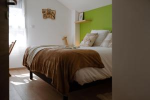 una camera con un letto con una parete verde di Le Clos De L'étang Jura a Frasne