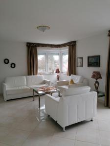 una sala de estar con sofás blancos y una mesa. en Haus Poseidon-Appartement Nr. 26, en Cuxhaven