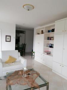 sala de estar con sofá blanco y mesa de cristal en Haus Poseidon-Appartement Nr. 26, en Cuxhaven