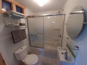 uma casa de banho com um WC, um lavatório e um espelho. em Beautiful Home on Sunny Acreage em Lunenburg