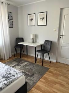 1 Schlafzimmer mit einem Tisch, 2 Stühlen und einem Bett in der Unterkunft Pokoje u Asi in Augustów