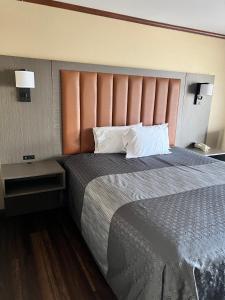 a bedroom with a large bed with a large headboard at Highland Inn Las Vegas in Las Vegas