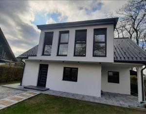 a white house with black windows at City house with garden, free parking in Graz