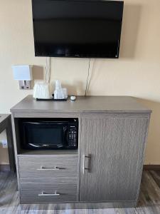a microwave on a cabinet with a television on top at Highland Inn Las Vegas in Las Vegas