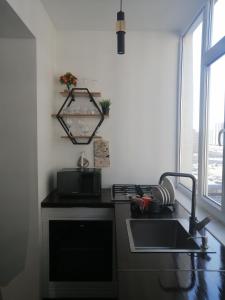 a kitchen with a sink and a stove and a window at Квартира посуточно in Aktau