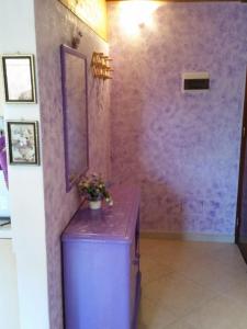 a room with a purple wall with a plant on it at CASA VIOLETTA - Grazioso Open Space in Quartucciu
