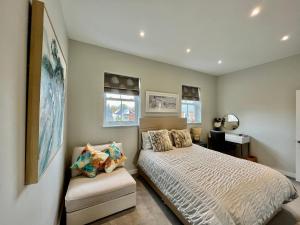 - une chambre avec un lit et une chaise dans l'établissement Entire house, Only 25 mins to London, FREE Cancellation 48hrs prior to arrival, à West Byfleet