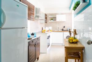 a kitchen with a white refrigerator and a wooden table at Home Amatista Málaga in Málaga