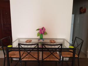 a table with chairs and a vase of flowers on it at Modern Apartment in Al Rehab City Center in Cairo