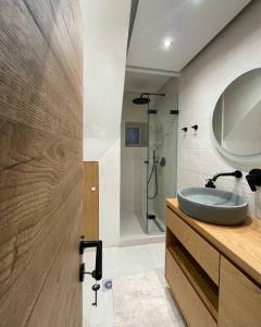 a bathroom with a sink and a shower with a mirror at Nespola di Campiello in Corfu