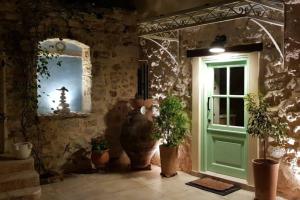 a room with a green door and potted plants at Nespola di Campiello in Corfu