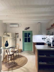 a kitchen with two chairs and a green door at Nespola di Campiello in Corfu Town