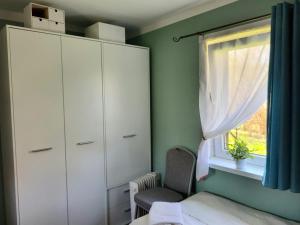 ein Schlafzimmer mit einem weißen Schrank und einem Fenster in der Unterkunft Dom Rybaka in Mirosławiec