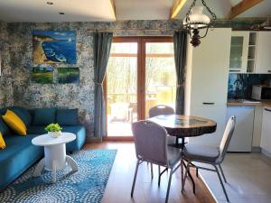 a living room with a blue couch and a table at Dom Rybaka in Mirosławiec