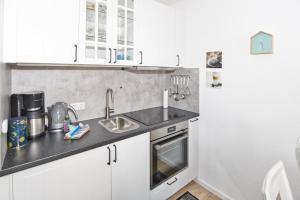 a kitchen with white cabinets and a sink at Residenz Albatros in Cuxhaven