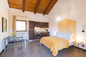 a bedroom with a large bed and a kitchen at Cascina 6B-Appartamenti Turistici & Business in San Maurizio Canavese