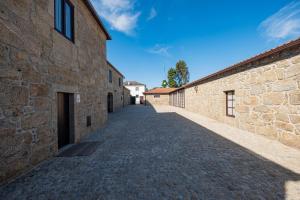 un callejón entre dos edificios de piedra con un cielo azul en Casa de Fervença 