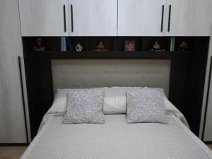 Bett mit weißem Kopfteil und weißen Kissen in der Unterkunft Il nido di Angelina - Ascea in Ascea
