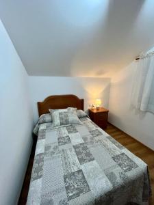 ein Schlafzimmer mit einem Bett mit einer Decke darauf in der Unterkunft Casa en San Pantaleón in Paderne