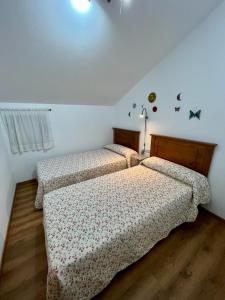 two twin beds in a room with white walls at Casa en San Pantaleón in Paderne