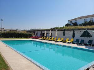una gran piscina con sillas y sombrillas en Casa de Fervença 