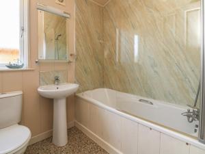 uma casa de banho com um lavatório, uma banheira e um WC. em Ocean Terrace 1 em Ilfracombe