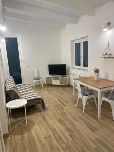 a living room with a table and a tv at Cà di Giaco lodge in Moneglia