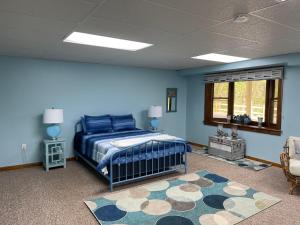 a bedroom with blue walls and a bed and a rug at Woodland Oasis in Cumberland