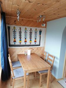 a table and chairs in a room with skis on the wall at Sognevegen 2242 in Haugsvær