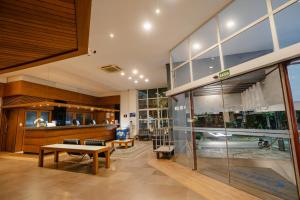 a lobby of a building with a bench and a table at Hotel Caiuá in Umuarama