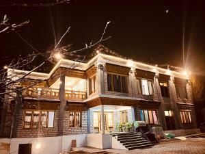 une grande maison éclairée la nuit dans l'établissement Ladakh Country Inn, à Leh