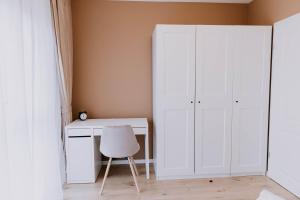 1 dormitorio con escritorio blanco y silla blanca en The Oasis, en Cluj-Napoca
