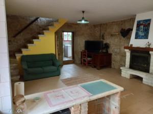 sala de estar con sofá verde y escalera en A CASA de FLORINDA, en Oia
