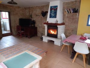 Una sala de estar con chimenea y una mesa. en A CASA de FLORINDA, en Oia