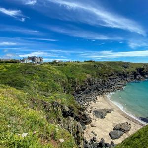 a house on top of a cliff next to a beach at Housel Bay Hotel in Lizard