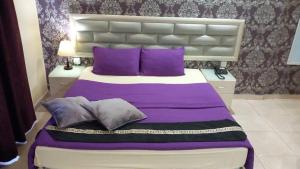 a bedroom with a large bed with purple pillows at Beirut Hotel in Amman