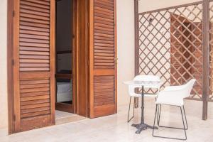 a patio with a table and chairs next to a door at Hotel Al Paradise in San Vito lo Capo