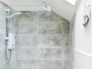 a shower stall in a bathroom with a tiled floor at The Barn in Llangwm