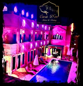 Casa d'Or Dahab PALAZZO في دهب: منزل به مسبح واضاءة وردية